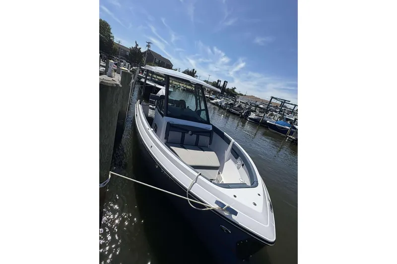Slide: The Image of 2026 Monterey 25 Elite boat docked in a sunny marina. - 2