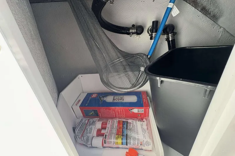 Slide: The Image of Storage compartment in 2026 Monterey 25 Elite boat with safety equipment and plumbing. - 21