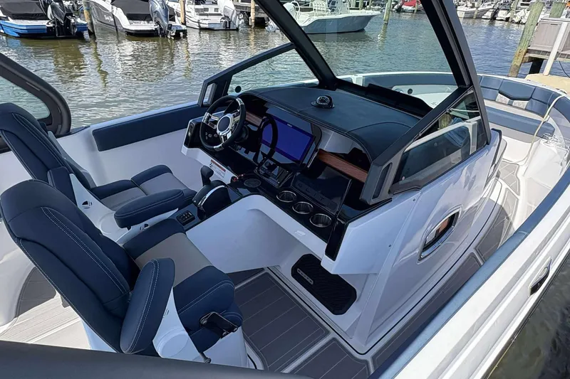 Slide: The Image of 2026 Monterey 25 Elite boat interior with modern dashboard and seating at marina. - 5