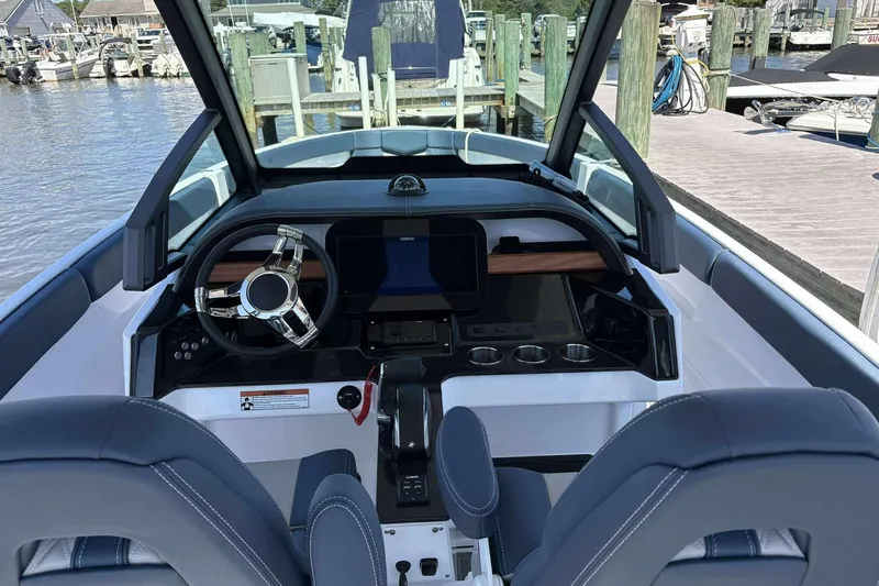 Slide: The Image of 2026 Monterey 25 Elite boat cockpit with modern steering and dashboard at marina. - 6