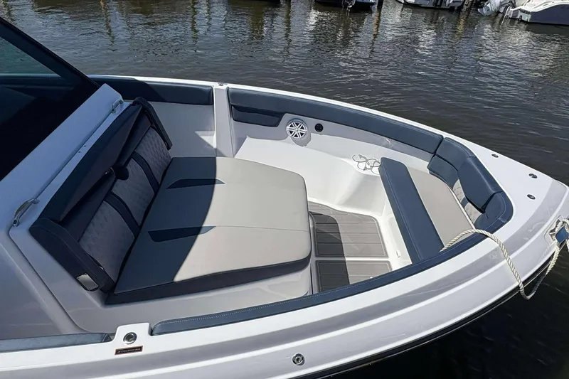Slide: The Image of 2026 Monterey 25 Elite boat interior with cushioned seating, docked on calm water. - 9