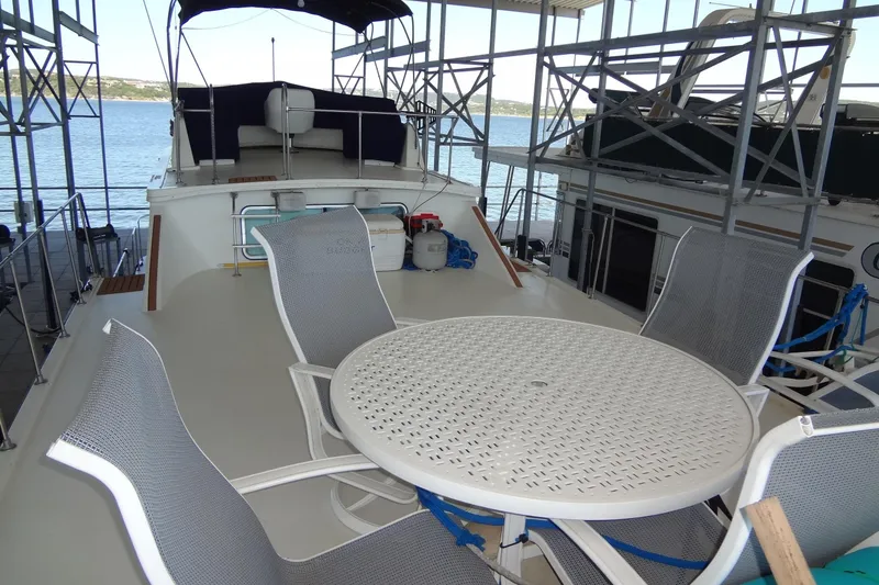Slide: The Image of 1995 Harbor Master 52 yacht deck with seating area and scenic water view. - 16