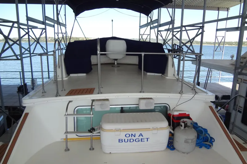 Slide: The Image of 1995 Harbor Master 52 boat docked, featuring upper deck with seating and "On a Budget" cooler. - 17