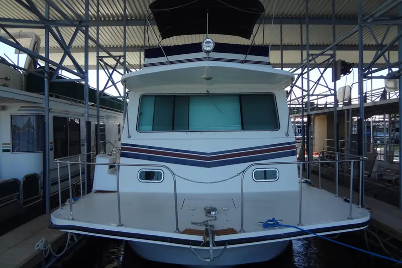 Slide: The Image of 1995 Harbor Master 52 houseboat docked in a covered marina. - 2