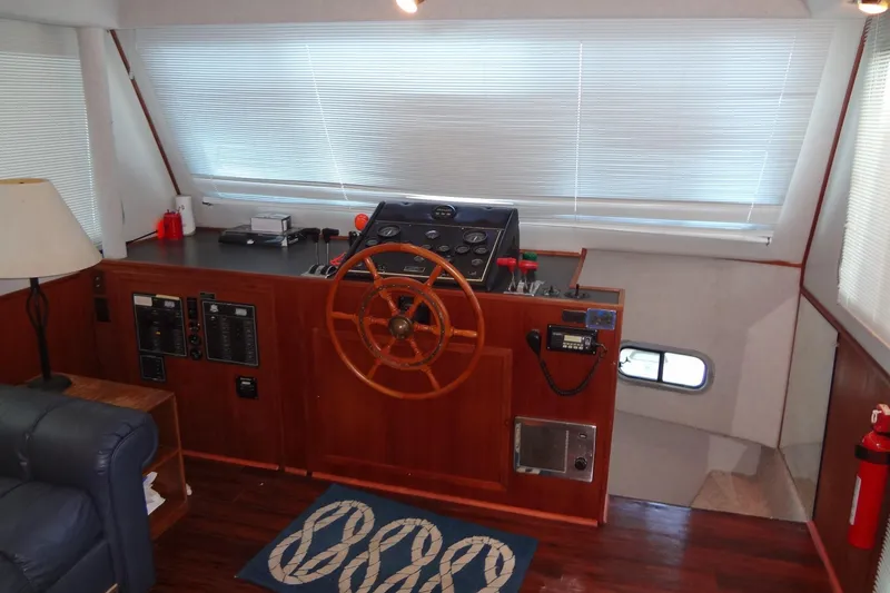 Slide: The Image of Interior helm of 1995 Harbor Master 52 yacht with wooden steering wheel and control panel. - 23
