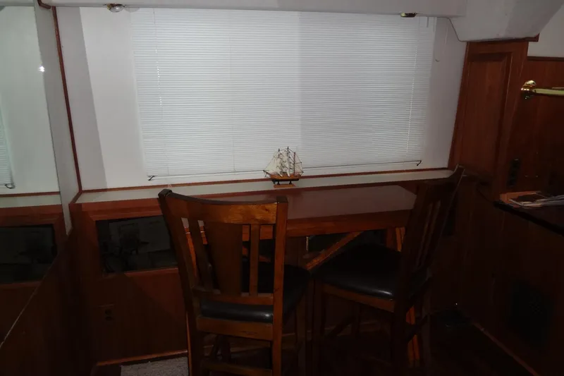Slide: The Image of Interior of 1995 Harbor Master 52 with wooden table and chairs, model ship decor. - 34