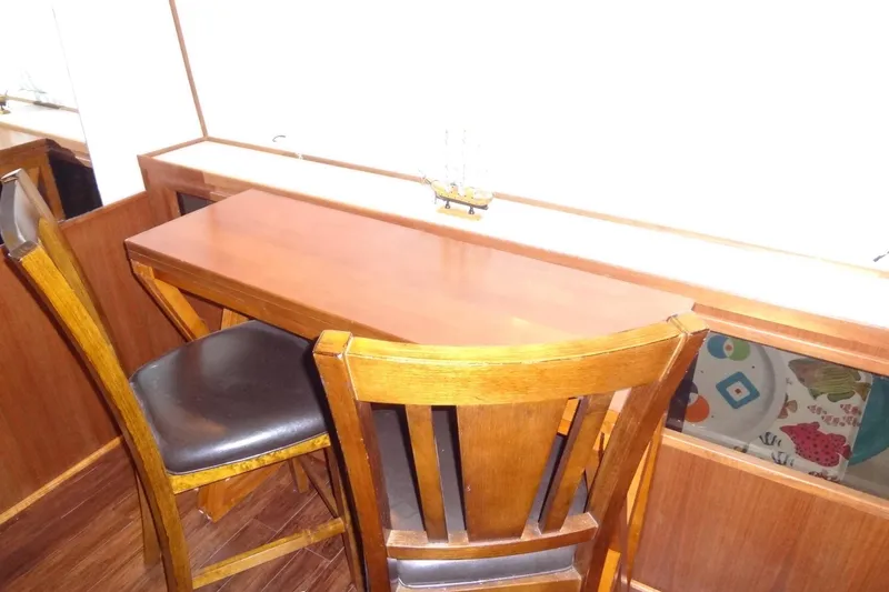 Slide: The Image of Wooden table and chairs inside a 1995 Harbor Master 52 boat interior. - 35