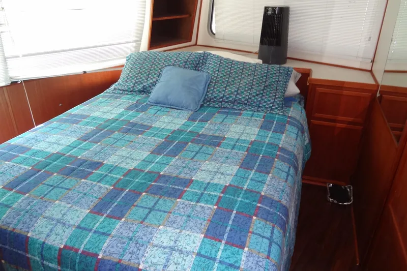 Slide: The Image of Cozy bedroom in 1995 Harbor Master 52 boat with blue checkered bedding. - 36