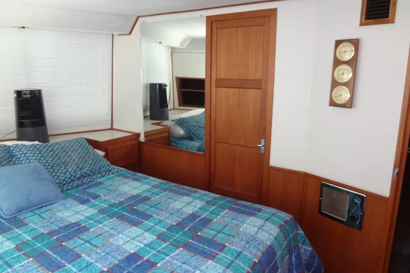 Slide: The Image of Cozy bedroom interior of 1995 Harbor Master 52 boat with wooden accents and plaid bedding. - 38