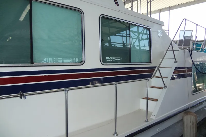 Slide: The Image of 1995 Harbor Master 52 boat with striped exterior and docked at marina. - 4