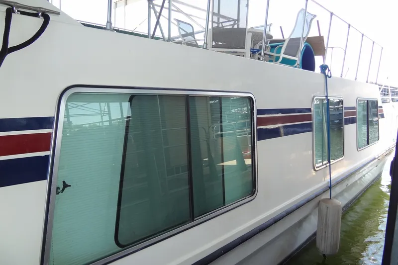 Slide: The Image of 1995 Harbor Master 52 houseboat with striped exterior and large windows docked at marina. - 5