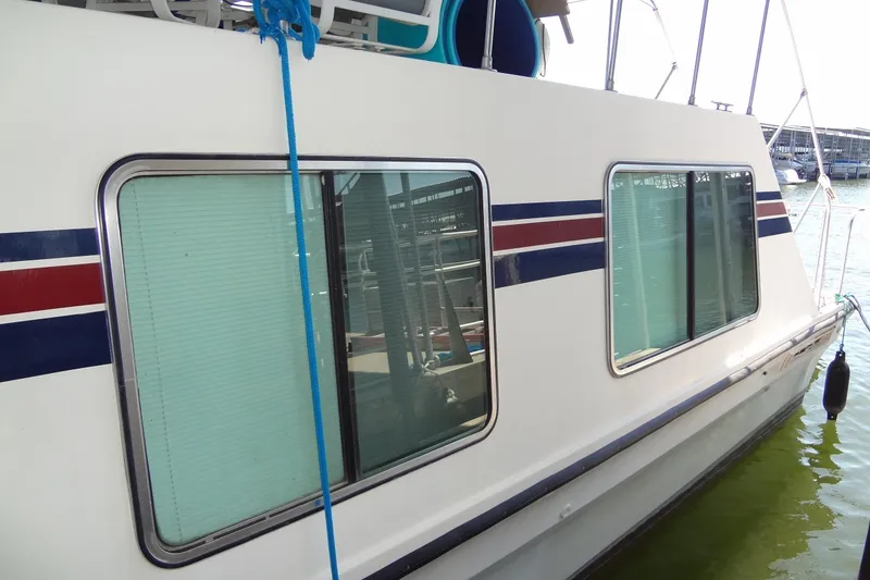 Slide: The Image of 1995 Harbor Master 52 houseboat with striped exterior and large windows docked at marina. - 6