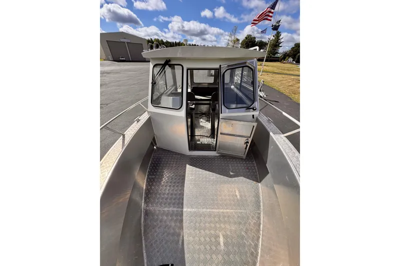 Slide: The Image of Stanley 27 Custom boat, 2018 model, docked with open cabin door, American flag in background. - 14