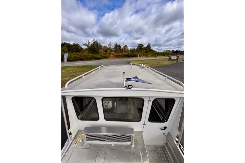 Slide: The Image of Stanley 27 Custom 2018 boat exterior with cloudy sky and greenery in background. - 2