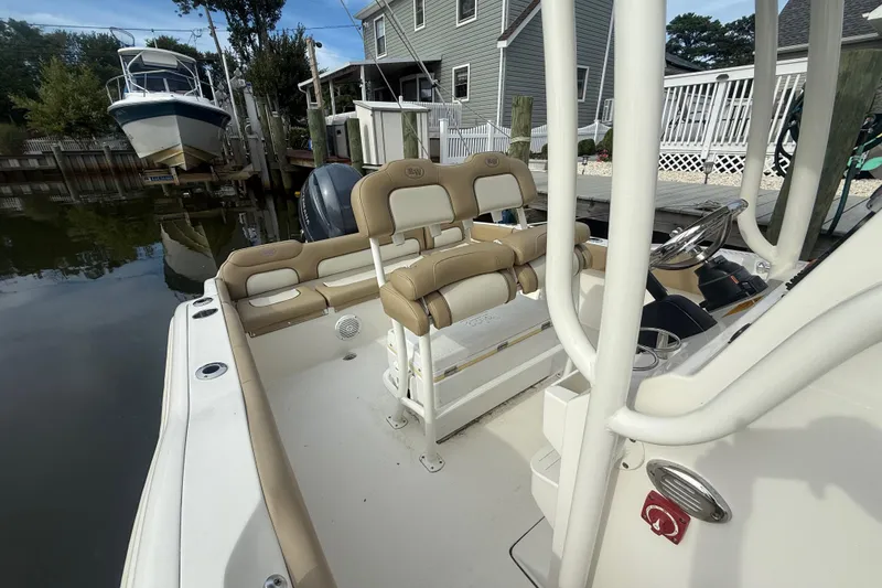 Slide: The Image of 2018 Key West 219 FS boat interior with beige seating, docked near waterfront homes. - 13