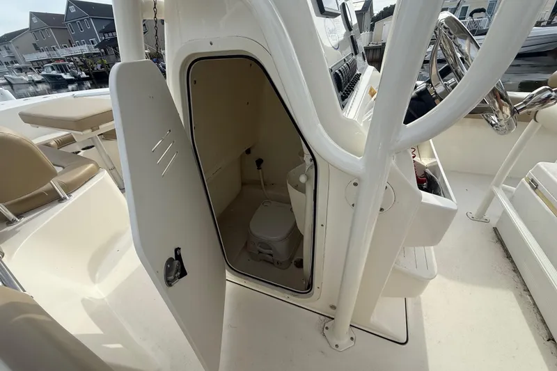 Slide: The Image of 2018 Key West 219 FS boat interior with open storage compartment and visible seating. - 19