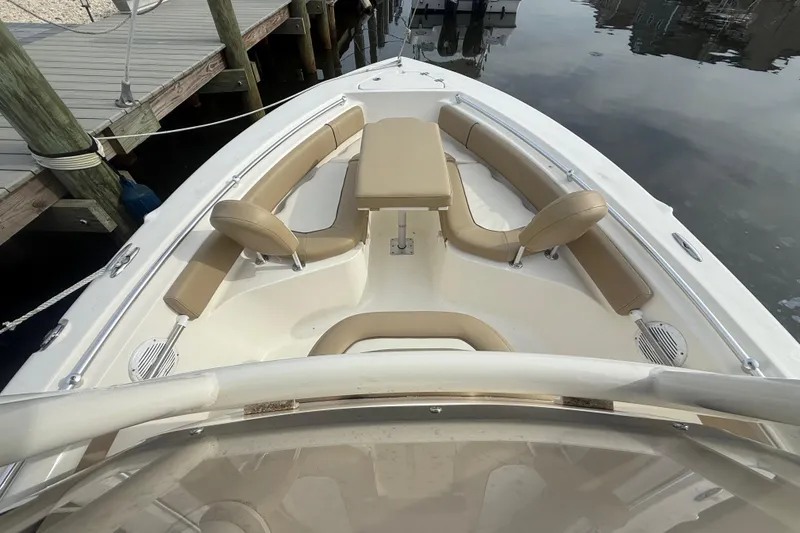 Slide: The Image of 2018 Key West 219 FS boat interior with tan seating, docked by wooden pier. - 21