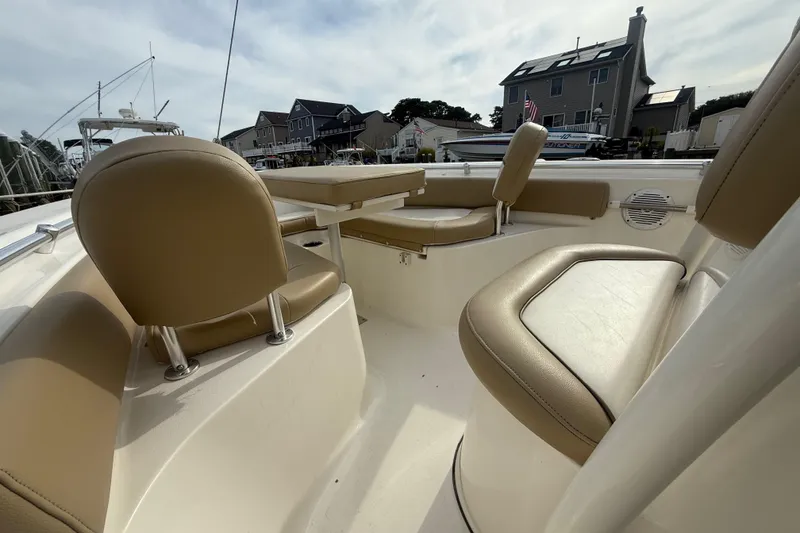 Slide: The Image of 2018 Key West 219 FS boat interior with tan seating and table, docked near houses. - 22