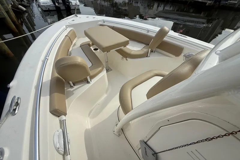 Slide: The Image of 2018 Key West 219 FS boat interior with beige seating and table, docked at marina. - 23