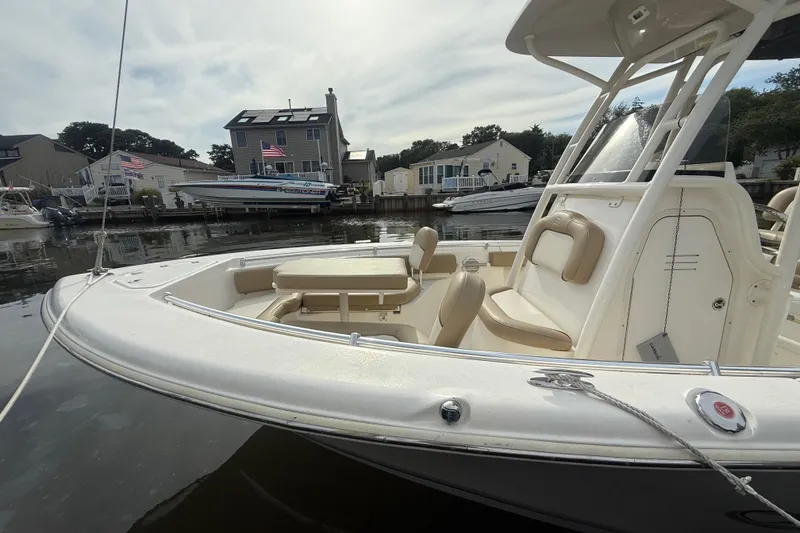 Slide: The Image of 2018 Key West 219 FS boat docked near waterfront homes, showcasing seating and helm. - 24