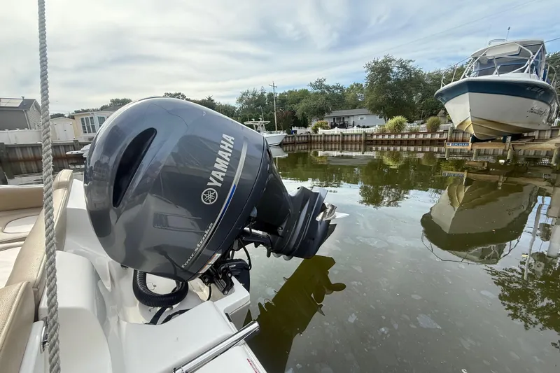 Slide: The Image of 2018 Key West 219 FS boat with Yamaha outboard motor in a calm marina. - 27