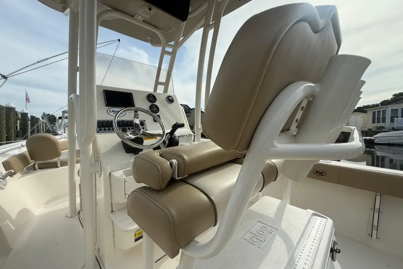 Slide: The Image of 2018 Key West 219 FS boat interior with steering wheel and seating, docked at marina. - 4