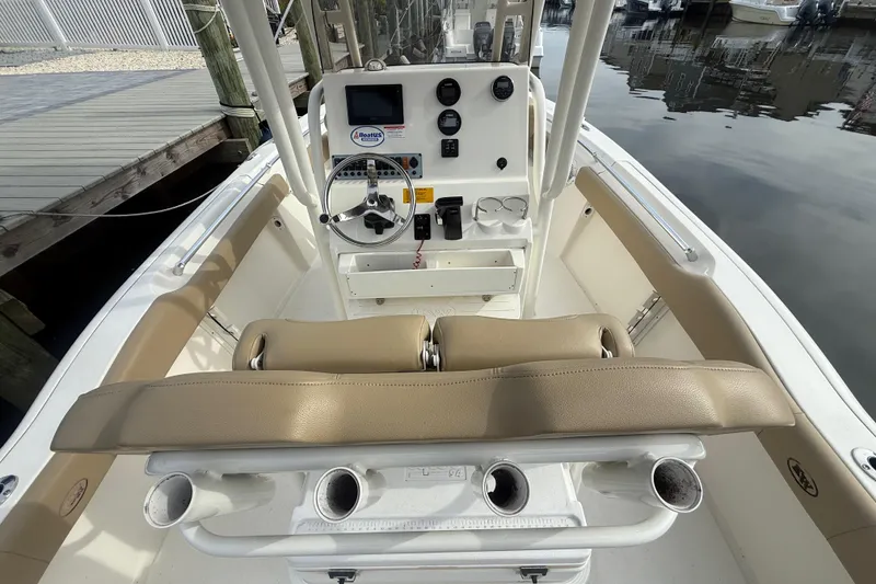 Slide: The Image of 2018 Key West 219 FS boat interior with steering console and seating at dock. - 7