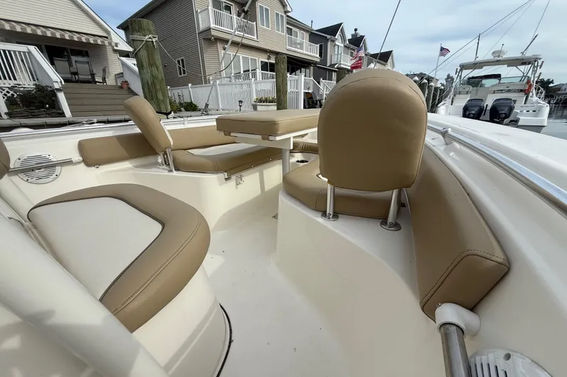Slide: The Image of 2018 Key West 219 FS boat interior with tan seating and table, docked near houses. - 8