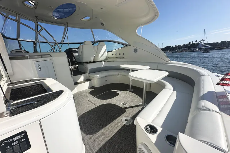 Slide: The Image of 2007 Cruisers Yachts 540 Express interior with seating, tables, and helm, overlooking water. - 12