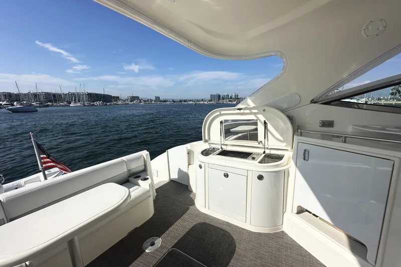 Slide: The Image of 2007 Cruisers Yachts 540 Express deck with seating and kitchenette, overlooking marina. - 13