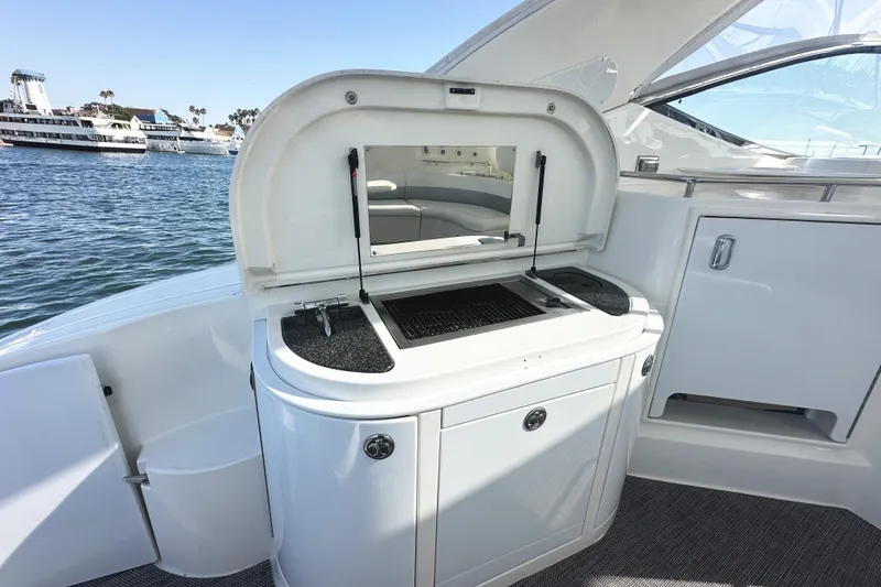 Slide: The Image of 2007 Cruisers Yachts 540 Express outdoor kitchen with grill, docked by the water. - 14