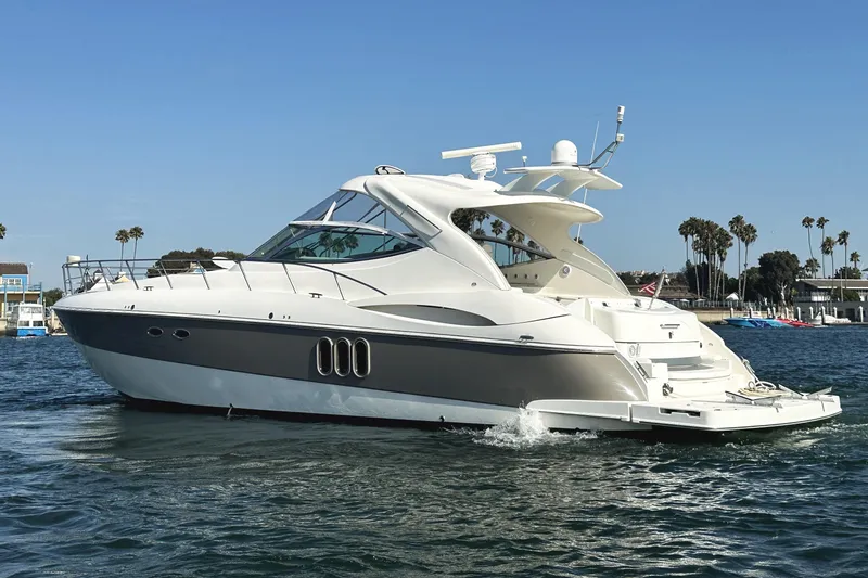 Slide: The Image of 2007 Cruisers Yachts 540 Express on water, sleek design, palm trees in background. - 2