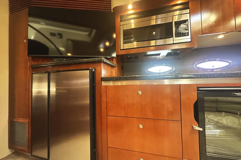Slide: The Image of Luxurious 2007 Cruisers Yachts 540 Express kitchen with modern appliances and wood cabinetry. - 27