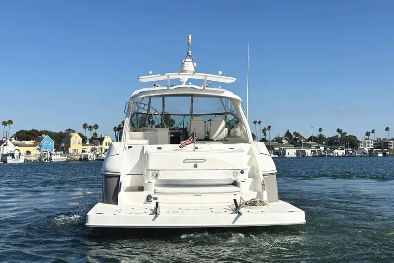 Slide: The Image of 2007 Cruisers Yachts 540 Express on water, with coastal houses in background. - 3