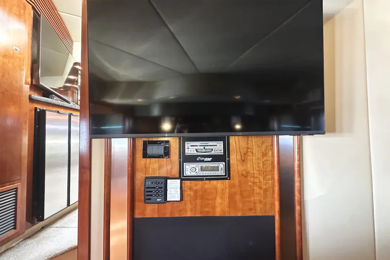Slide: The Image of Entertainment system in 2007 Cruisers Yachts 540 Express, featuring a flat-screen TV and audio controls. - 38