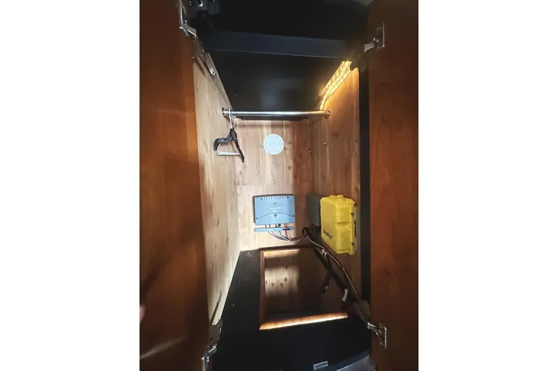 Slide: The Image of 2007 Cruisers Yachts 540 Express interior storage with electrical components and lighting. - 41