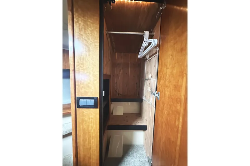 Slide: The Image of 2007 Cruisers Yachts 540 Express interior closet with wooden finish and hangers. - 45