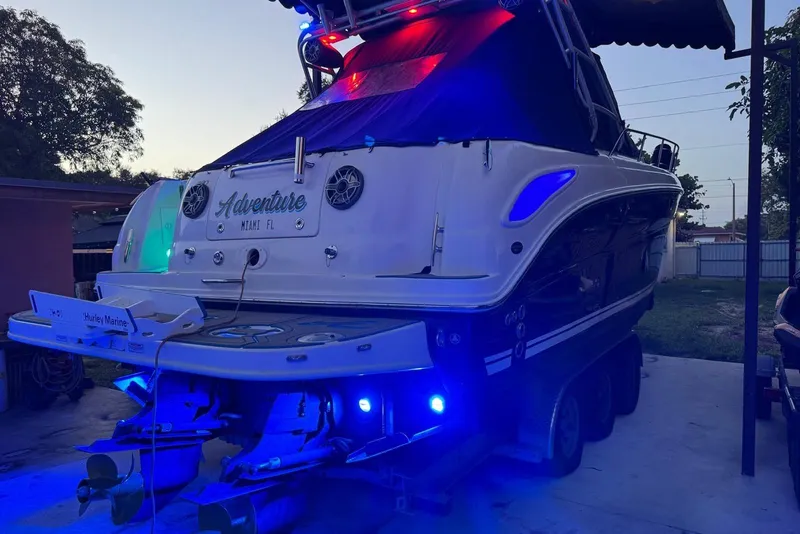The Image of 2006 Sea Ray 290 Amberjack boat with blue lights, docked at sunset. - 0