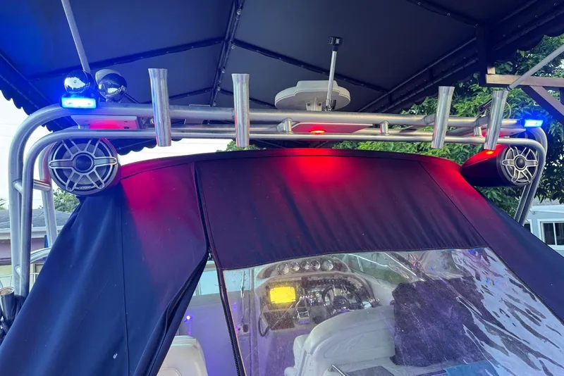 Slide: The Image of Cozy 2006 Sea Ray 290 Amberjack cabin with red lighting and striped bedding. - 14