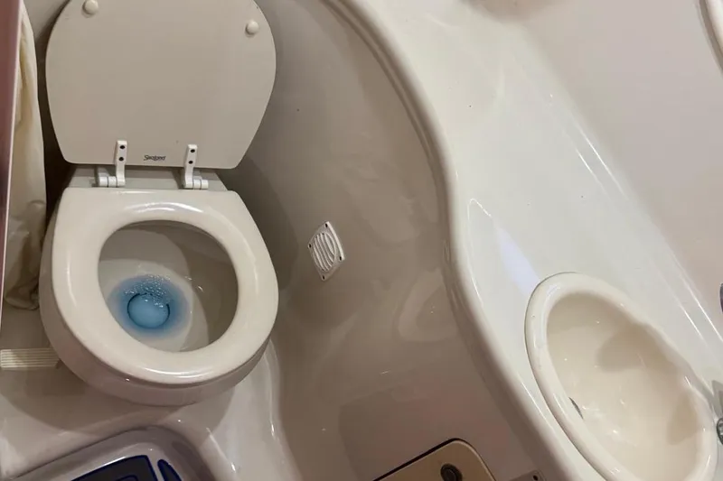 Slide: The Image of 2006 Sea Ray 290 Amberjack with blue canvas cover and visible cockpit window. - 19