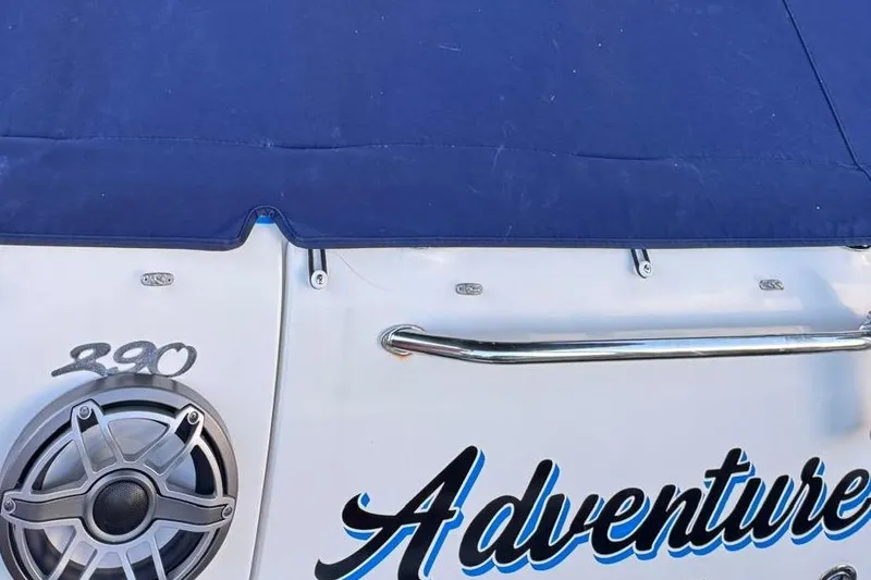 Slide: The Image of 2006 Sea Ray 290 Amberjack boat on trailer, parked under a canopy with blue lighting. - 23