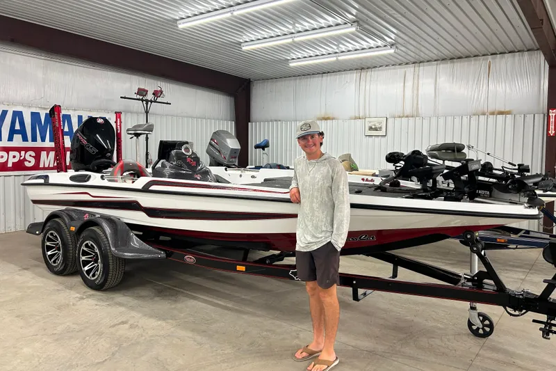 Slide: The Image of 2023 Bass Cat Eyra boat in showroom with person standing beside it. - 0