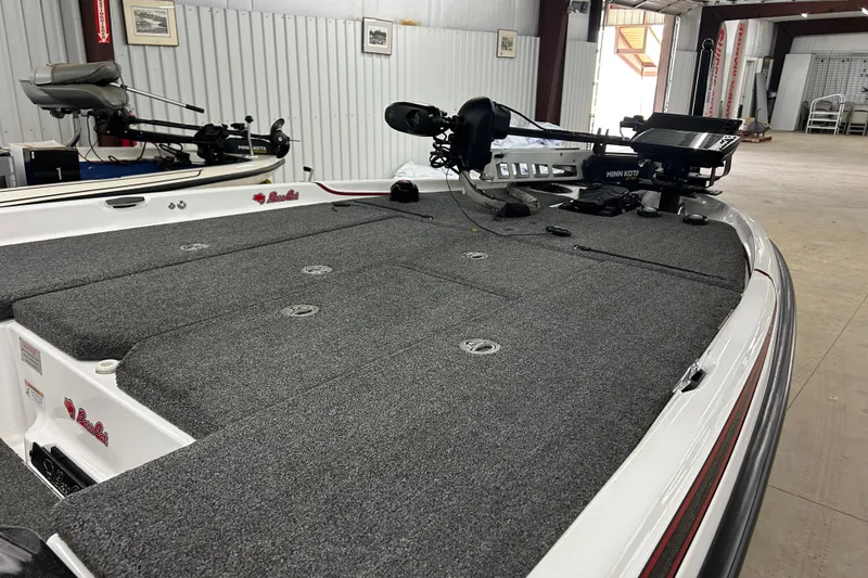 Slide: The Image of 2023 Bass Cat Eyra boat with Minn Kota trolling motor in a garage setting. - 2