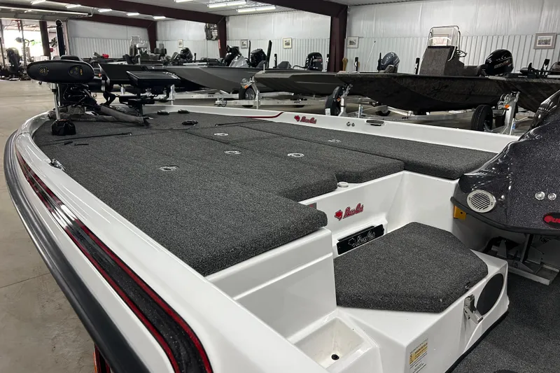 Slide: The Image of 2023 Bass Cat Eyra boat interior with gray carpet and storage compartments. - 3