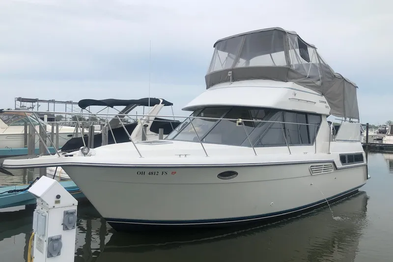 Slide: The Image of 1995 Carver 325 Aft Cabin boat docked in marina, featuring enclosed flybridge. - 1