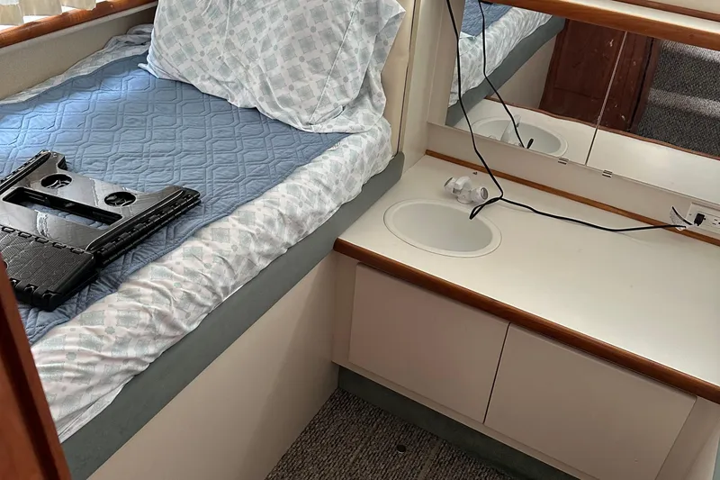 Slide: The Image of 1995 Carver 325 Aft Cabin interior with bed, sink, and mirror. - 13