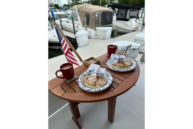 Slide: The Image of Breakfast setup on 1995 Carver 325 Aft Cabin yacht with American flag in marina. - 15