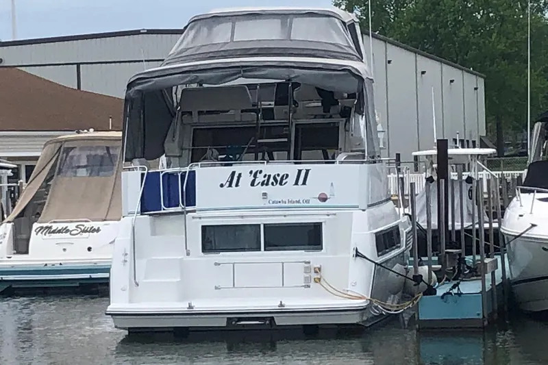 Slide: The Image of 1995 Carver 325 Aft Cabin boat docked, named "At 'Ease II," with covered upper deck. - 2