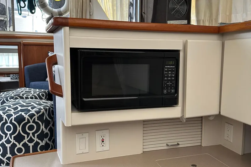 Slide: The Image of Microwave in 1995 Carver 325 Aft Cabin yacht kitchen, featuring modern cabinetry and outlets. - 8