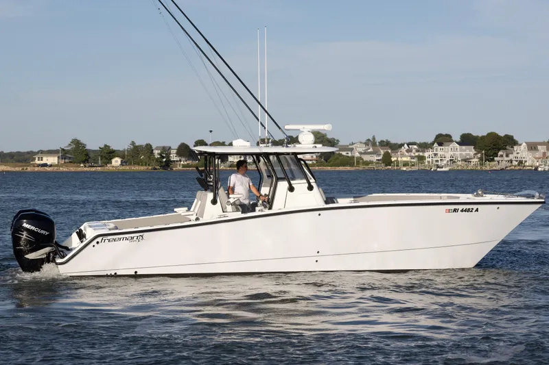 Slide: The Image of 2020 Freeman 34VH boat cruising on a calm waterway near residential shoreline. - 10